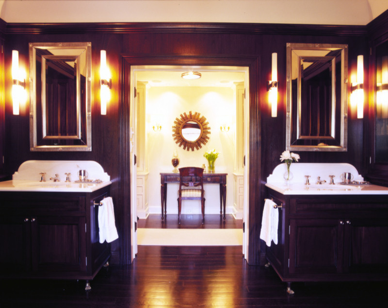 Cette image montre une salle de bain principale traditionnelle avec un plan de toilette en marbre, un mur marron et parquet foncé.