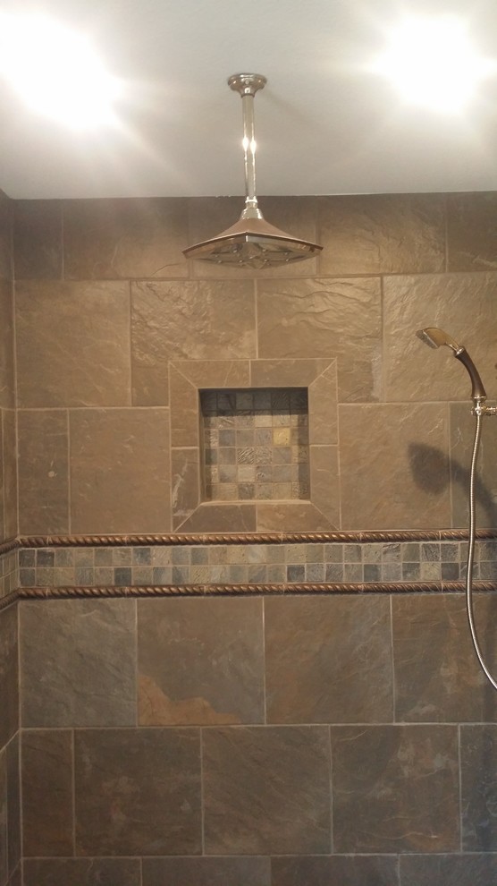 Großes Uriges Duschbad mit braunen Schränken, freistehender Badewanne, Eckdusche, brauner Wandfarbe, Marmorboden, Granit-Waschbecken/Waschtisch und weißem Boden in Dallas