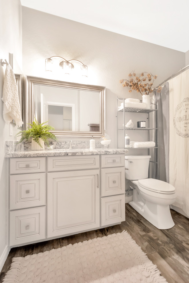 Klassisk inredning av ett mellanstort grå grått badrum för barn, med luckor med upphöjd panel, grå skåp, en öppen dusch, grå kakel, porslinskakel, grå väggar, klinkergolv i porslin, ett undermonterad handfat, granitbänkskiva, grått golv och med dusch som är öppen