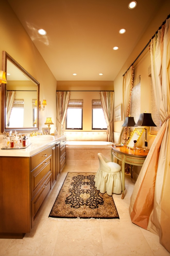 Klassisches Badezimmer mit Einbauwaschbecken, profilierten Schrankfronten, hellbraunen Holzschränken, Einbaubadewanne und beigen Fliesen in Denver