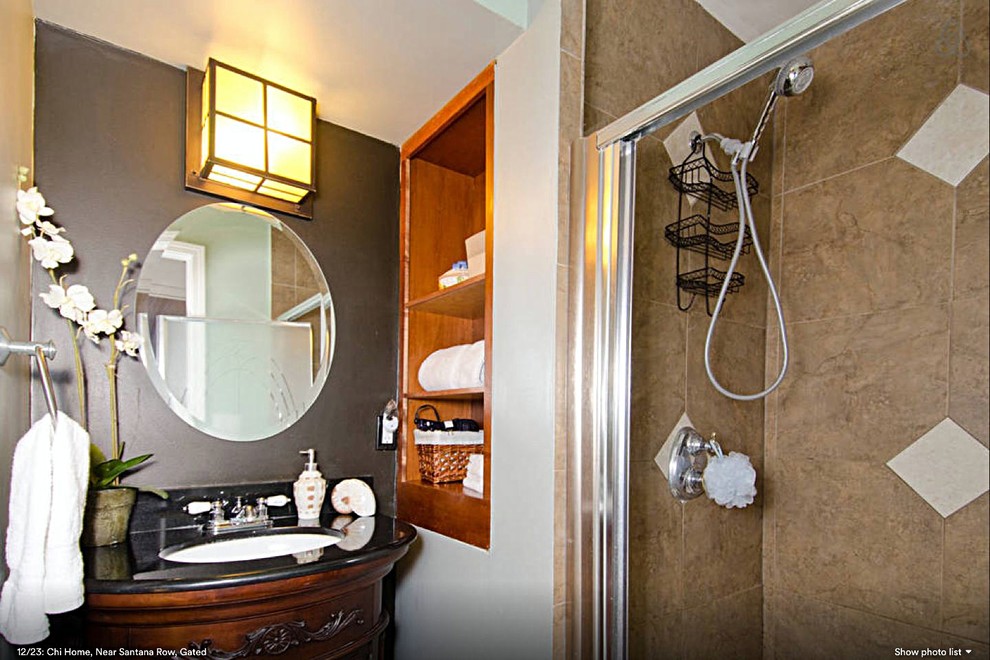 Asiatisk inredning av ett litet en-suite badrum, med ett fristående handfat, möbel-liknande, skåp i mörkt trä, granitbänkskiva, ett badkar i en alkov, en dusch/badkar-kombination, en toalettstol med separat cisternkåpa, beige kakel, porslinskakel, grå väggar och klinkergolv i porslin