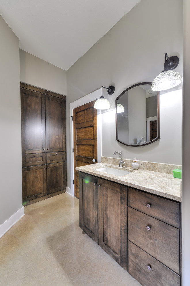 Foto de cuarto de baño principal rural grande con armarios con paneles empotrados, puertas de armario de madera oscura, bañera con patas, ducha abierta, sanitario de una pieza, baldosas y/o azulejos multicolor, baldosas y/o azulejos de piedra, paredes grises, suelo de cemento, lavabo bajoencimera y encimera de granito