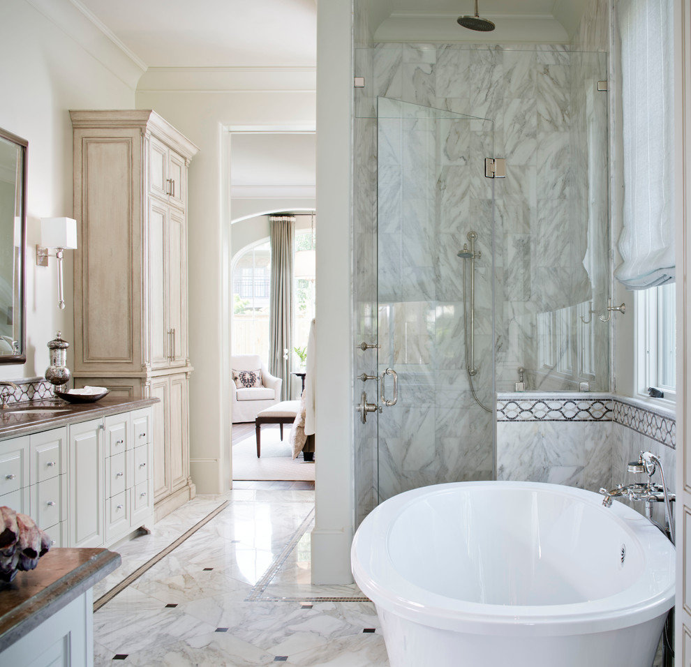 На фото: большая главная ванная комната в средиземноморском стиле с накладной раковиной, мраморной столешницей, отдельно стоящей ванной, угловым душем, унитазом-моноблоком, серой плиткой, каменной плиткой, белыми стенами и мраморным полом с
