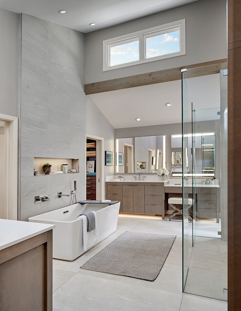 Exempel på ett mycket stort modernt vit vitt en-suite badrum, med släta luckor, bruna skåp, ett fristående badkar, en öppen dusch, grå kakel, porslinskakel, grå väggar, klinkergolv i porslin, ett undermonterad handfat, bänkskiva i kvarts, grått golv och med dusch som är öppen