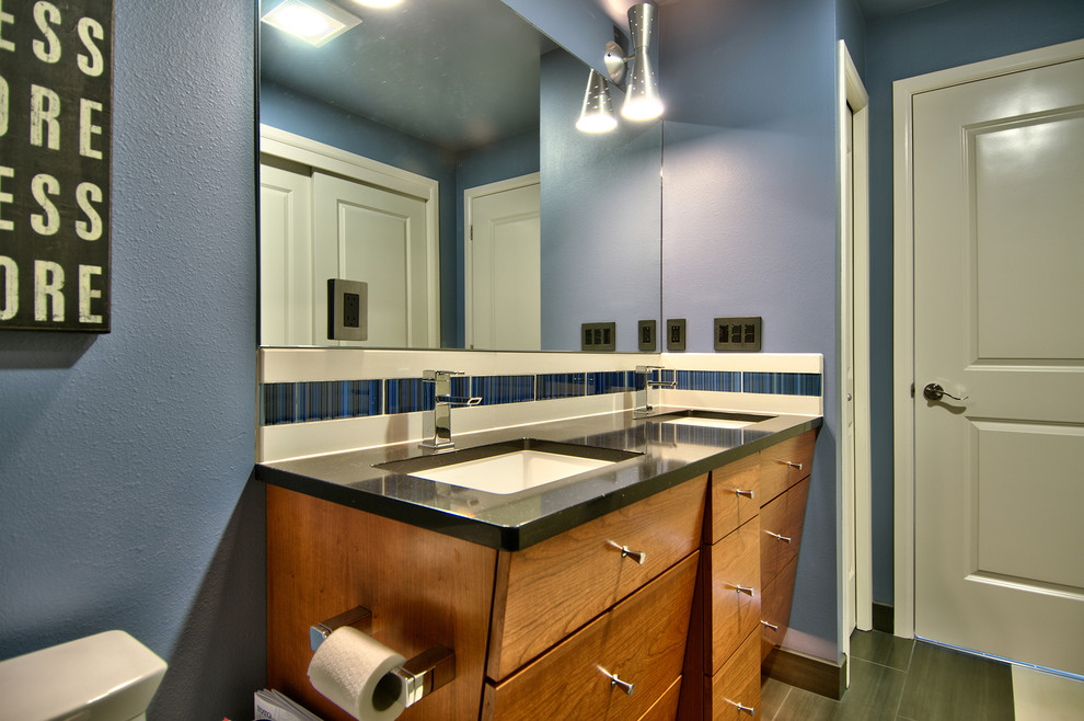 This is an example of a contemporary bathroom in Seattle with flat-panel cabinets, medium wood cabinets, blue tiles, white tiles, blue walls, a submerged sink, engineered stone worktops and grey floors.