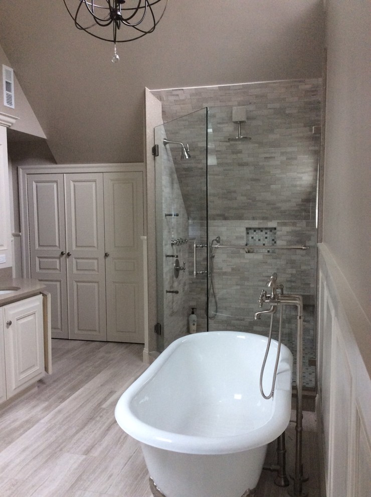 Example of a large transitional master stone tile bathroom design in New York with raised-panel cabinets, white cabinets, beige walls, an undermount sink, a hinged shower door, a two-piece toilet and quartz countertops