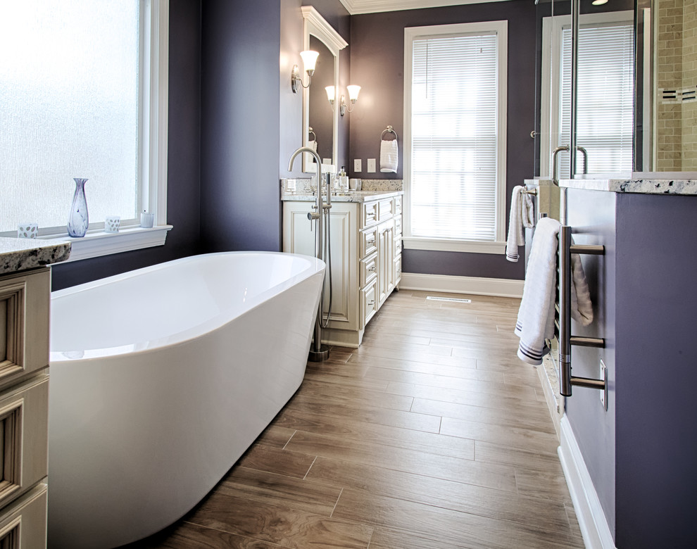 Стильный дизайн: большая главная ванная комната в классическом стиле с отдельно стоящей ванной, фиолетовыми стенами, врезной раковиной, фасадами островного типа, белыми фасадами, столешницей из гранита, двойным душем, коричневой плиткой, полом из керамической плитки и коричневым полом - последний тренд