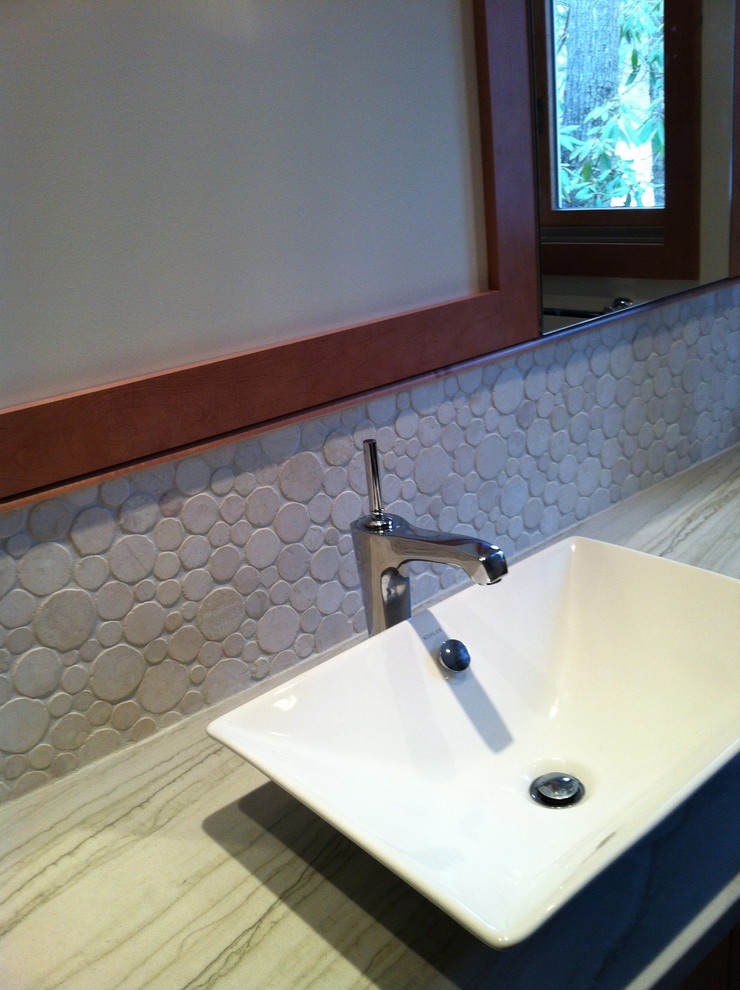 Cette image montre une petite salle de bain design en bois clair avec un carrelage beige, un mur blanc, un sol en carrelage de céramique, une vasque, un plan de toilette en onyx, un sol beige, une cabine de douche à porte coulissante et un placard avec porte à panneau encastré.