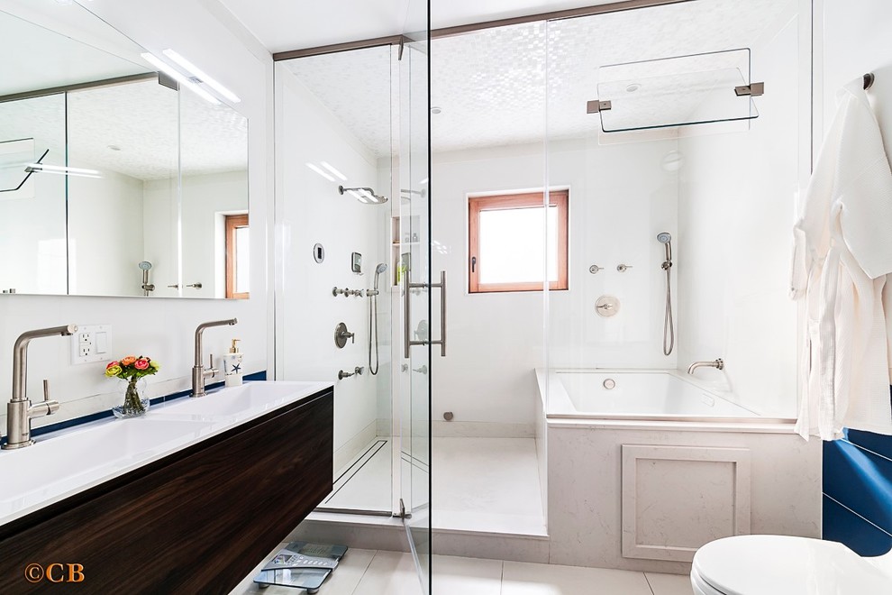 На фото: ванная комната в стиле модернизм с темными деревянными фасадами, душем над ванной и белыми стенами с