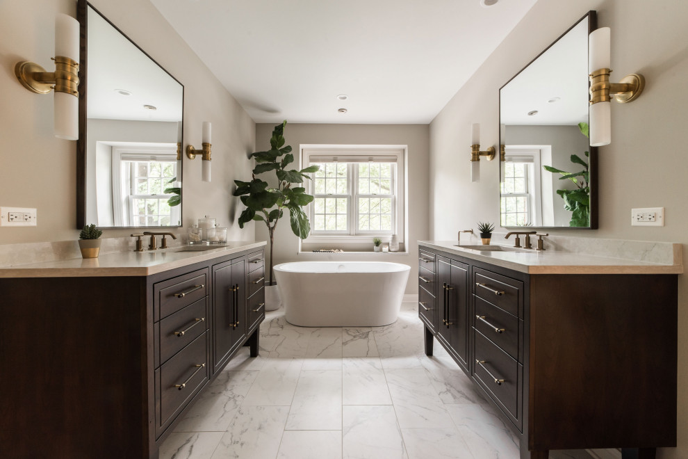 Transitional master marble floor, multicolored floor and double-sink freestanding bathtub photo in Chicago with dark wood cabinets, beige walls, an undermount sink, marble countertops, beige countertops, a built-in vanity and flat-panel cabinets