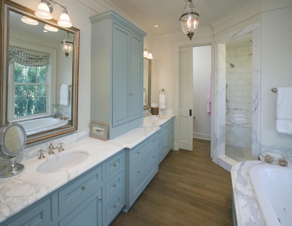 Exemple d'une salle de bain chic avec une douche d'angle, des portes de placard bleues et une porte coulissante.