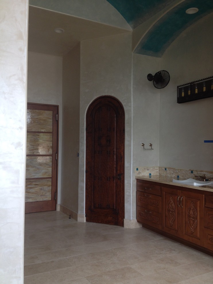 Aménagement d'une grande salle de bain principale méditerranéenne en bois brun avec un placard avec porte à panneau surélevé, une baignoire indépendante, une douche ouverte, WC à poser, un carrelage beige, un carrelage de pierre, un mur blanc, un sol en travertin, un lavabo posé et un plan de toilette en onyx.