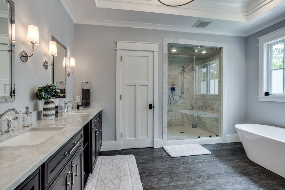 Bathroom - large craftsman master gray tile ceramic tile bathroom idea in DC Metro with raised-panel cabinets, dark wood cabinets, a two-piece toilet, gray walls, an integrated sink and marble countertops