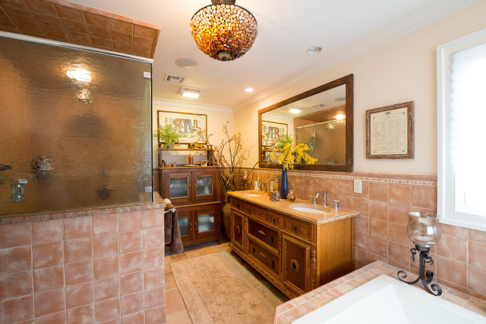 Aménagement d'une grande douche en alcôve principale bord de mer en bois brun avec un placard à porte vitrée, un plan de toilette en granite, un carrelage rose, des carreaux de céramique, une baignoire d'angle, un lavabo encastré et un mur blanc.