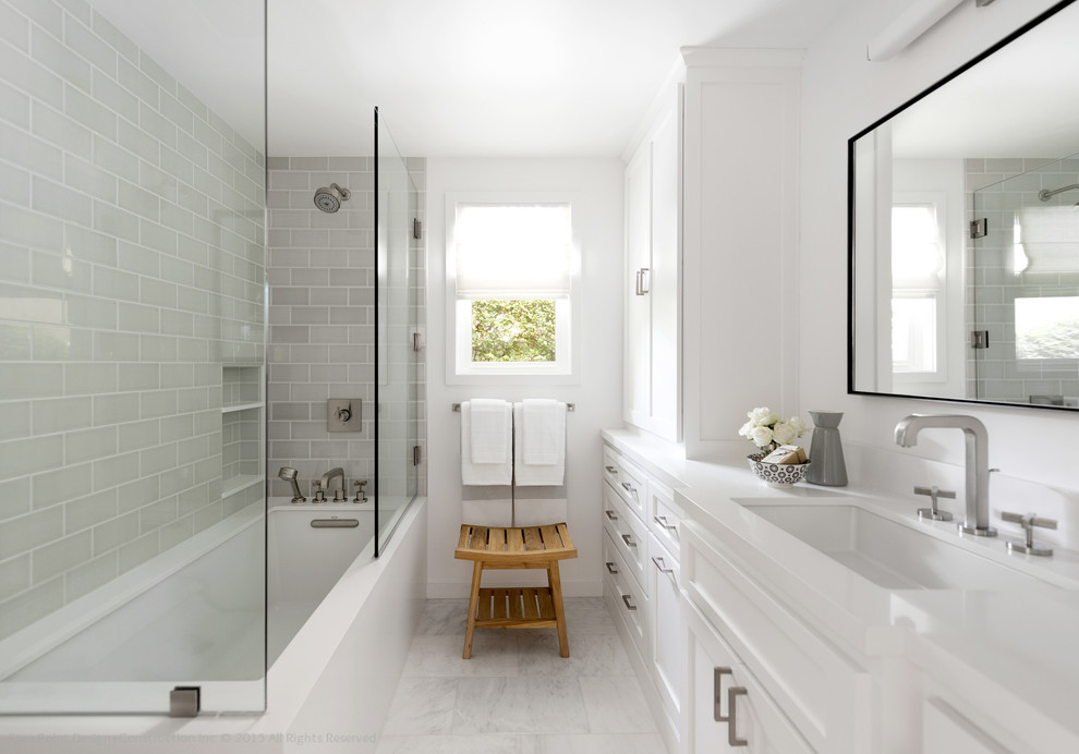 Photo of a small contemporary ensuite bathroom in Los Angeles with shaker cabinets, white cabinets, a submerged bath, a shower/bath combination, a two-piece toilet, grey tiles, metro tiles, white walls, marble flooring, a submerged sink and solid surface worktops.