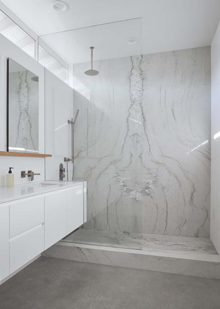 Minimalist master gray tile and stone slab concrete floor and green floor bathroom photo in Orange County with flat-panel cabinets, white cabinets, a two-piece toilet, white walls, an undermount sink and white countertops
