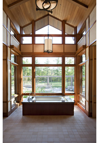 Aménagement d'une très grande salle de bain contemporaine avec une baignoire indépendante, un carrelage marron, un carrelage de pierre et un mur marron.