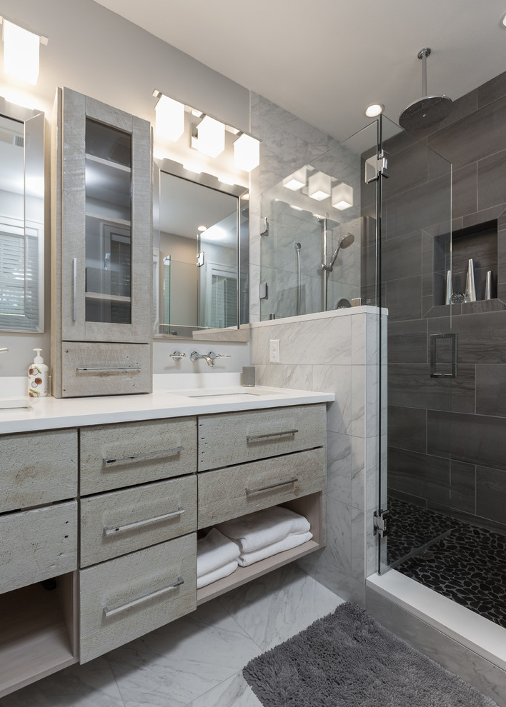 Example of a mid-sized minimalist master multicolored tile and porcelain tile pebble tile floor bathroom design in Other with distressed cabinets, a wall-mount toilet, gray walls, an undermount sink and quartz countertops