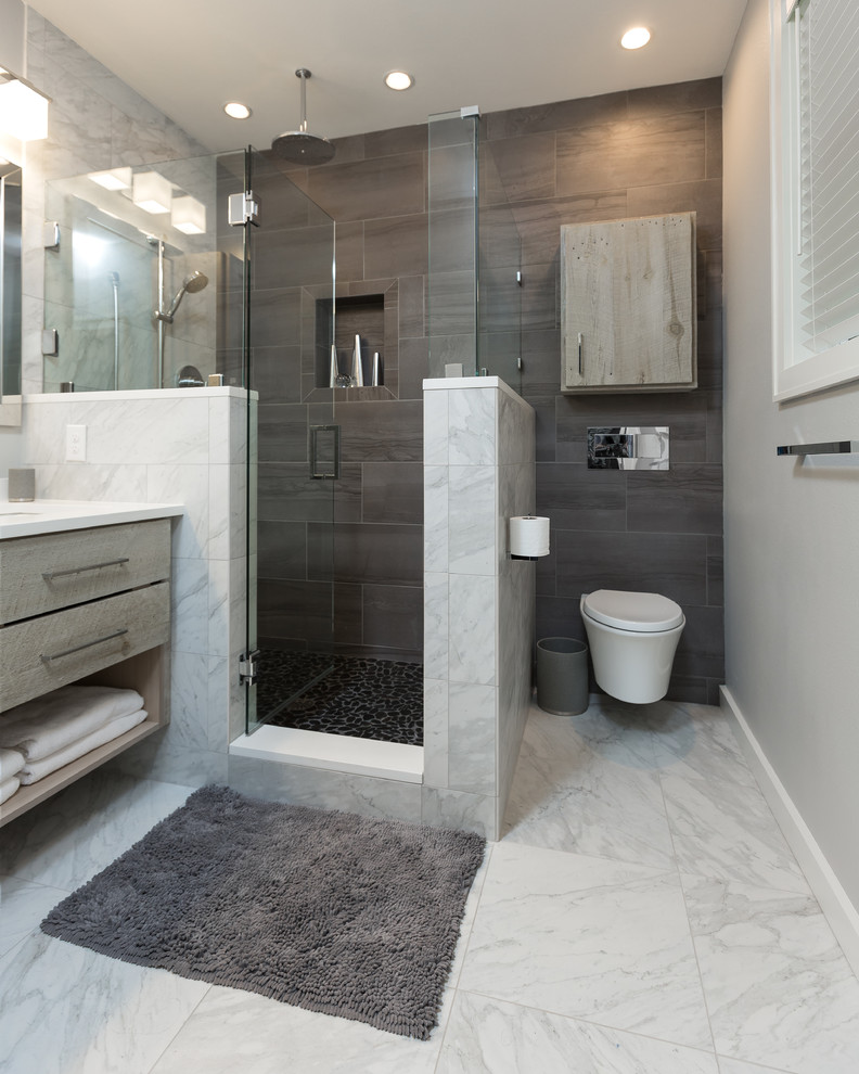 Idée de décoration pour une salle de bain principale minimaliste en bois vieilli de taille moyenne avec WC suspendus, un carrelage multicolore, des carreaux de porcelaine, un mur gris, un sol en galet, un lavabo encastré et un plan de toilette en quartz modifié.