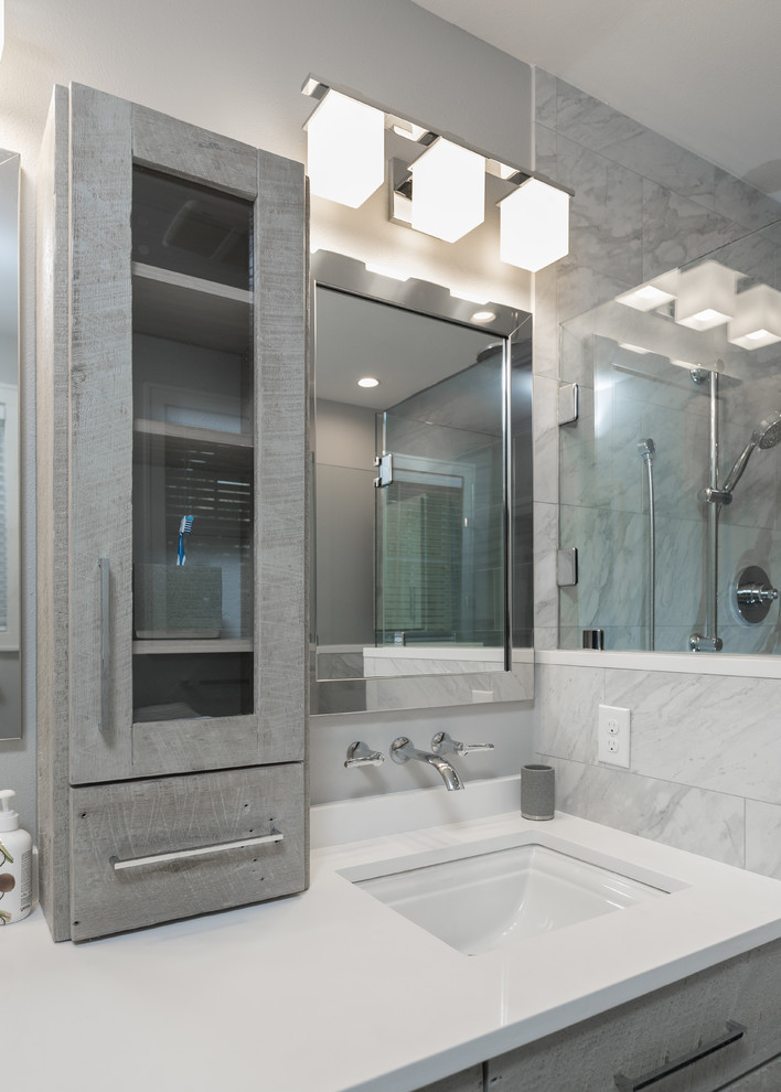 На фото: главная ванная комната среднего размера в стиле модернизм с искусственно-состаренными фасадами, инсталляцией, разноцветной плиткой, керамогранитной плиткой, серыми стенами, полом из галечной плитки, врезной раковиной и столешницей из искусственного кварца с