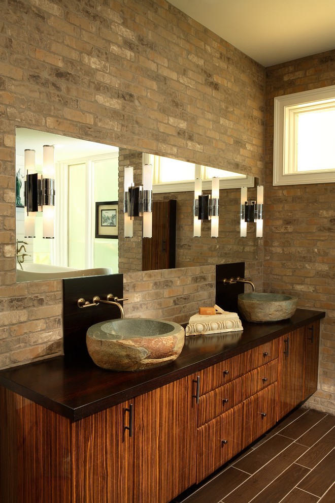Свежая идея для дизайна: большая главная ванная комната в современном стиле с настольной раковиной, плоскими фасадами, фасадами цвета дерева среднего тона, столешницей из дерева, отдельно стоящей ванной, угловым душем, раздельным унитазом, коричневой плиткой, керамогранитной плиткой, полом из керамогранита, коричневыми стенами, коричневым полом и душем с распашными дверями - отличное фото интерьера