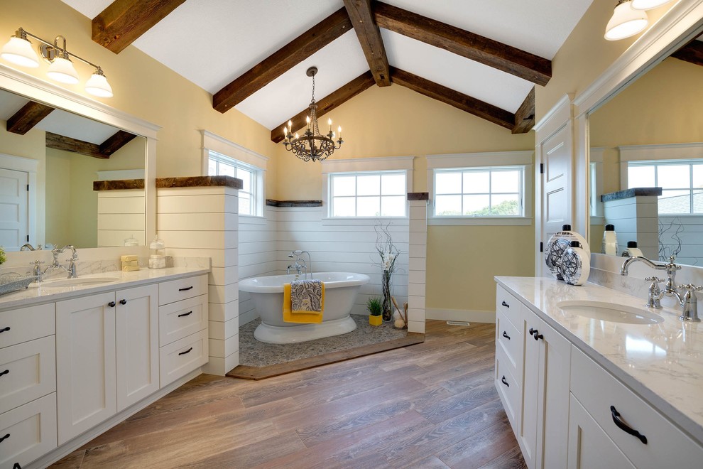 Idéer för lantliga badrum, med skåp i shakerstil, vita skåp, ett fristående badkar, brun kakel, gula väggar, ett undermonterad handfat och granitbänkskiva