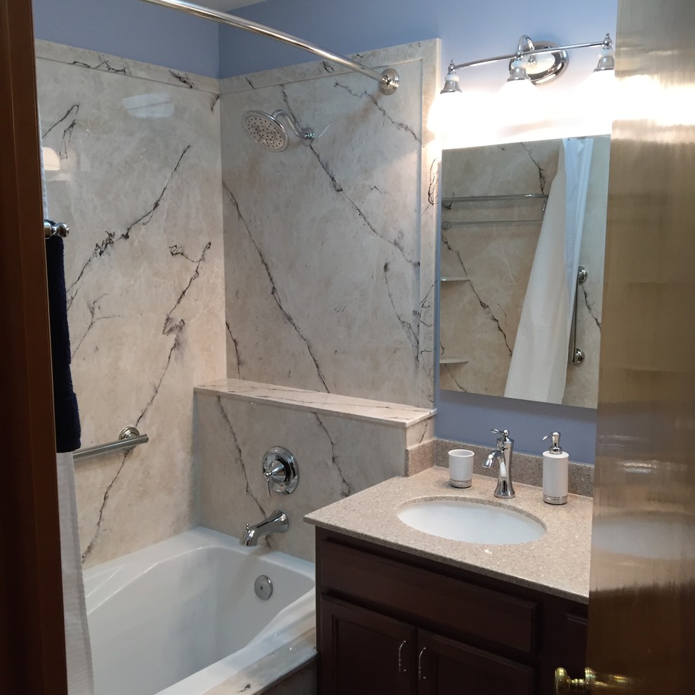 Exempel på ett mellanstort klassiskt en-suite badrum, med luckor med infälld panel, skåp i mellenmörkt trä, ett badkar i en alkov, en dusch/badkar-kombination, en toalettstol med separat cisternkåpa, blå väggar, klinkergolv i keramik, ett undermonterad handfat, bänkskiva i akrylsten, dusch med duschdraperi och brunt golv