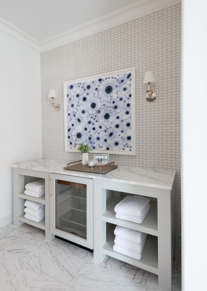 Foto de cuarto de baño principal clásico grande con armarios abiertos, puertas de armario grises, paredes blancas, suelo de mármol, suelo blanco y papel pintado