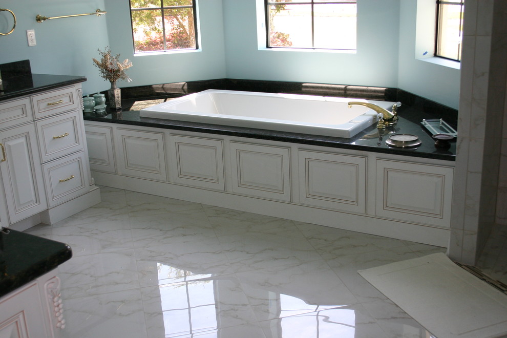 Aménagement d'une grande salle de bain principale classique avec un placard à porte plane, un plan de toilette en granite et un sol en marbre.