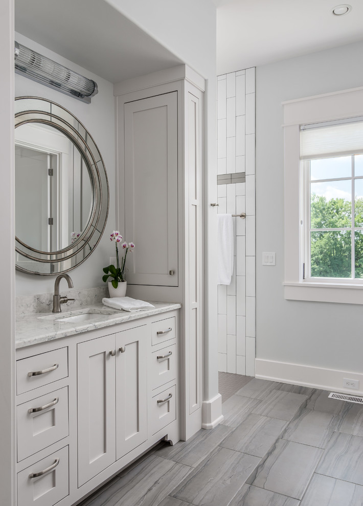Exempel på ett klassiskt vit vitt en-suite badrum, med luckor med profilerade fronter, vita skåp, en öppen dusch, en toalettstol med separat cisternkåpa, vit kakel, porslinskakel, grå väggar, klinkergolv i keramik, ett undermonterad handfat, bänkskiva i kvarts, grått golv och med dusch som är öppen