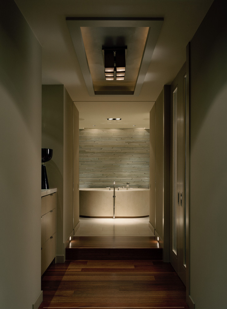This is an example of a contemporary bathroom in Seattle with a freestanding bath and limestone tiles.