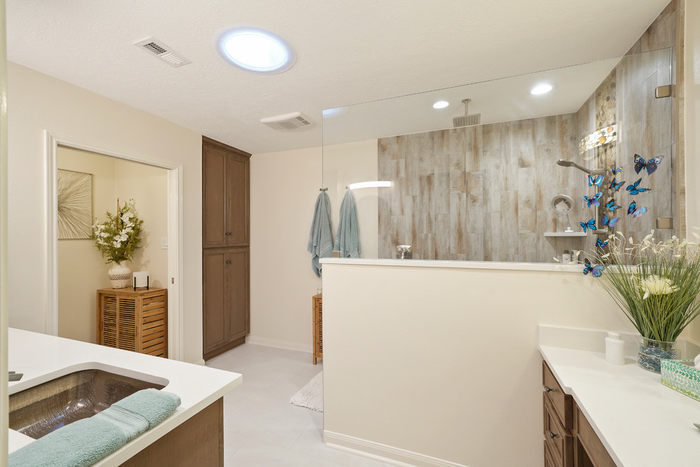 This is an example of a medium sized contemporary ensuite bathroom in Houston with recessed-panel cabinets, light wood cabinets, a built-in shower, a two-piece toilet, white tiles, pebble tiles, a submerged sink, engineered stone worktops, an open shower and white worktops.