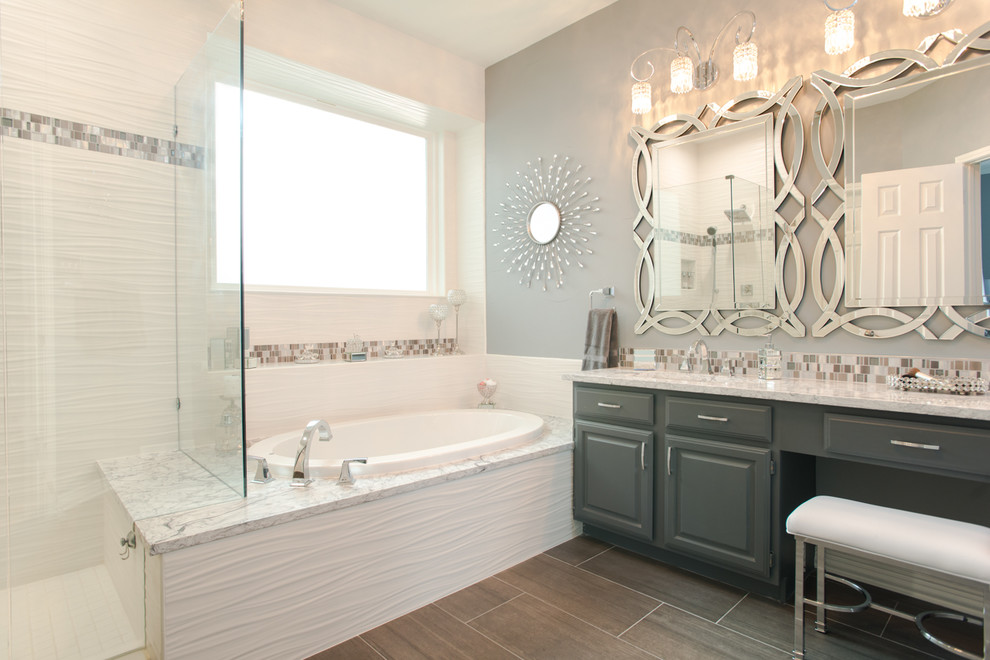 ダラスにあるコンテンポラリースタイルのおしゃれな浴室 (グレーのキャビネット、ドロップイン型浴槽、大理石の洗面台、グレーの洗面カウンター) の写真
