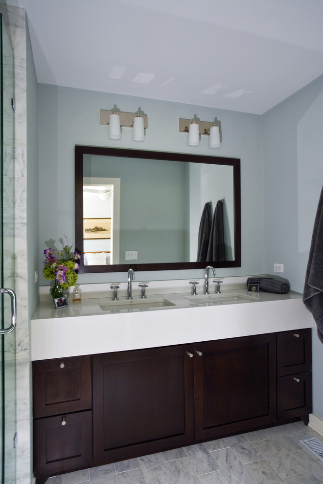 На фото: главная ванная комната среднего размера в современном стиле с фасадами в стиле шейкер, темными деревянными фасадами, душем в нише, раздельным унитазом, серой плиткой, мраморной плиткой, синими стенами, мраморным полом, врезной раковиной, столешницей из искусственного кварца, серым полом, душем с распашными дверями, белой столешницей, сиденьем для душа, тумбой под две раковины и встроенной тумбой с