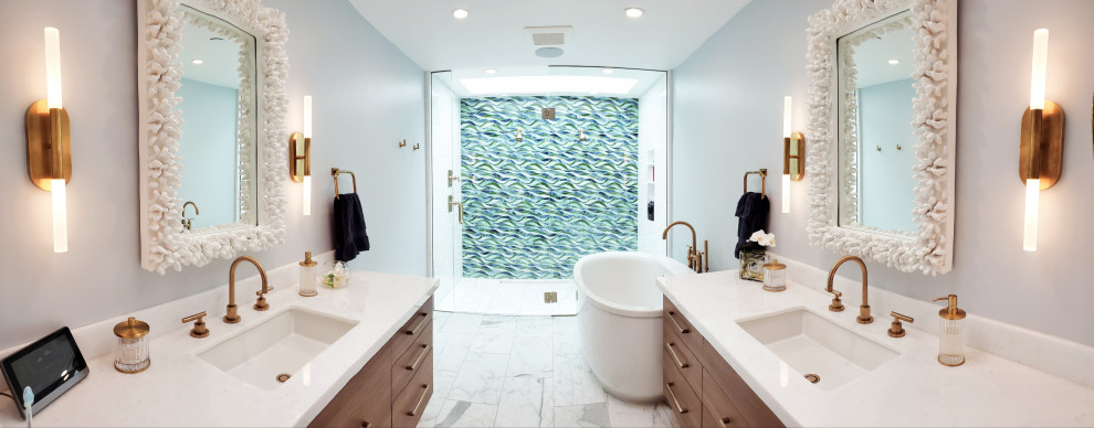 Пример оригинального дизайна: главный совмещенный санузел среднего размера в морском стиле с плоскими фасадами, светлыми деревянными фасадами, отдельно стоящей ванной, душем без бортиков, унитазом-моноблоком, разноцветной плиткой, плиткой из листового стекла, серыми стенами, мраморным полом, врезной раковиной, столешницей из искусственного кварца, белым полом, душем с распашными дверями, белой столешницей, тумбой под две раковины и напольной тумбой