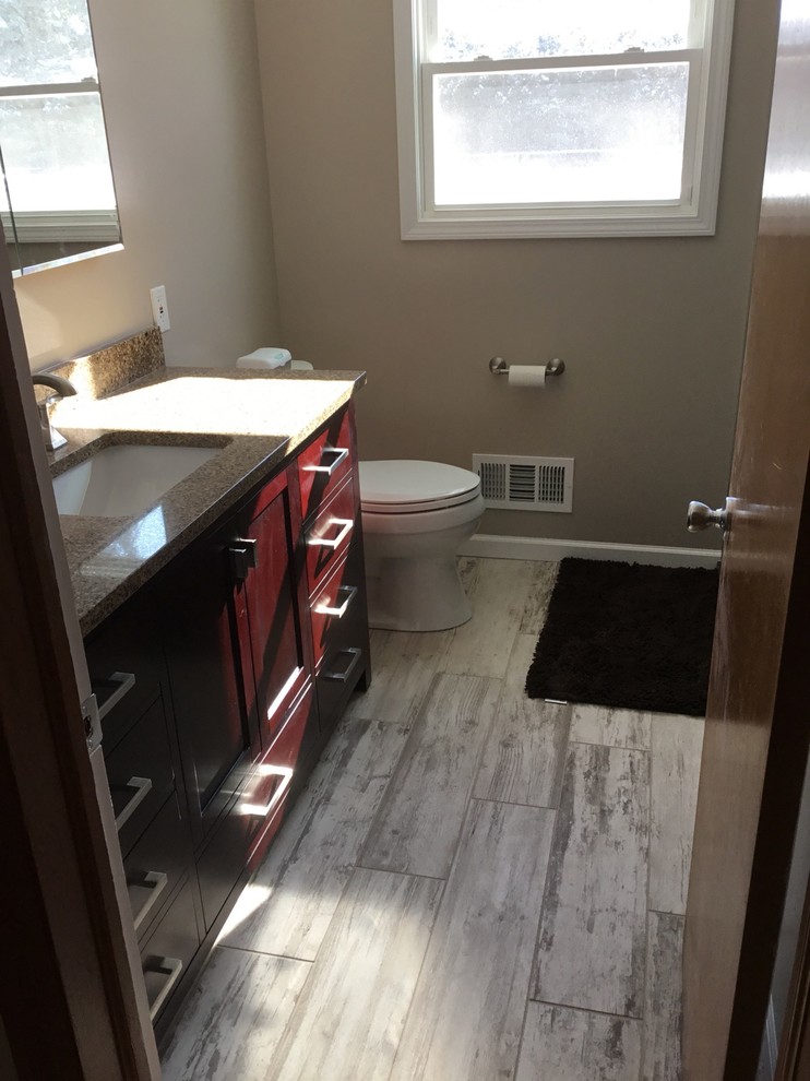 Cette image montre une salle de bain principale design de taille moyenne avec un mur gris, un sol en carrelage de céramique, un lavabo encastré et un plan de toilette en marbre.
