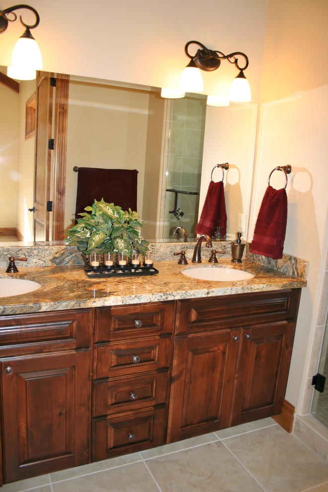 This is an example of a rustic bathroom in Phoenix with a submerged sink, raised-panel cabinets, medium wood cabinets, glass worktops, beige tiles, porcelain tiles and porcelain flooring.