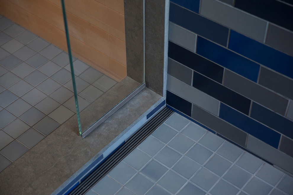 Idéer för stora funkis en-suite badrum, med blå kakel, keramikplattor, klinkergolv i keramik, blått golv, släta luckor, skåp i ljust trä, ett undermonterat badkar, våtrum, bruna väggar, ett undermonterad handfat och dusch med gångjärnsdörr