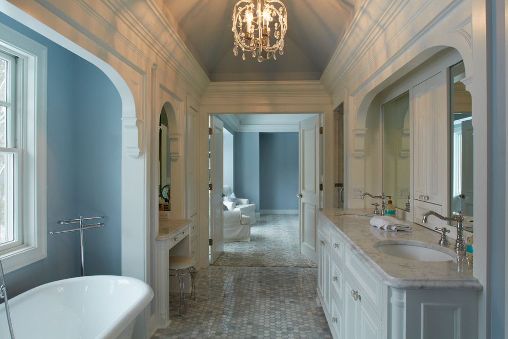 Ejemplo de cuarto de baño principal clásico renovado de tamaño medio con armarios con paneles empotrados, puertas de armario blancas, bañera exenta, paredes azules, suelo de mármol, lavabo bajoencimera, encimera de mármol y suelo gris