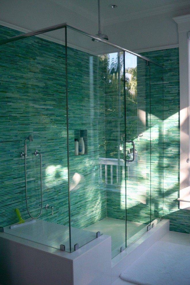マイアミにある広いトロピカルスタイルのおしゃれなマスターバスルーム (置き型浴槽、アルコーブ型シャワー、青いタイル、緑のタイル、ガラスタイル、緑の壁、磁器タイルの床) の写真