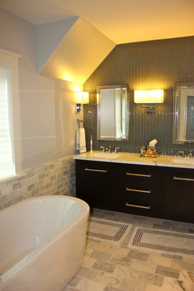 Idéer för att renovera ett funkis en-suite badrum, med marmorbänkskiva, ett fristående badkar, skåp i mörkt trä, grå kakel och stenkakel