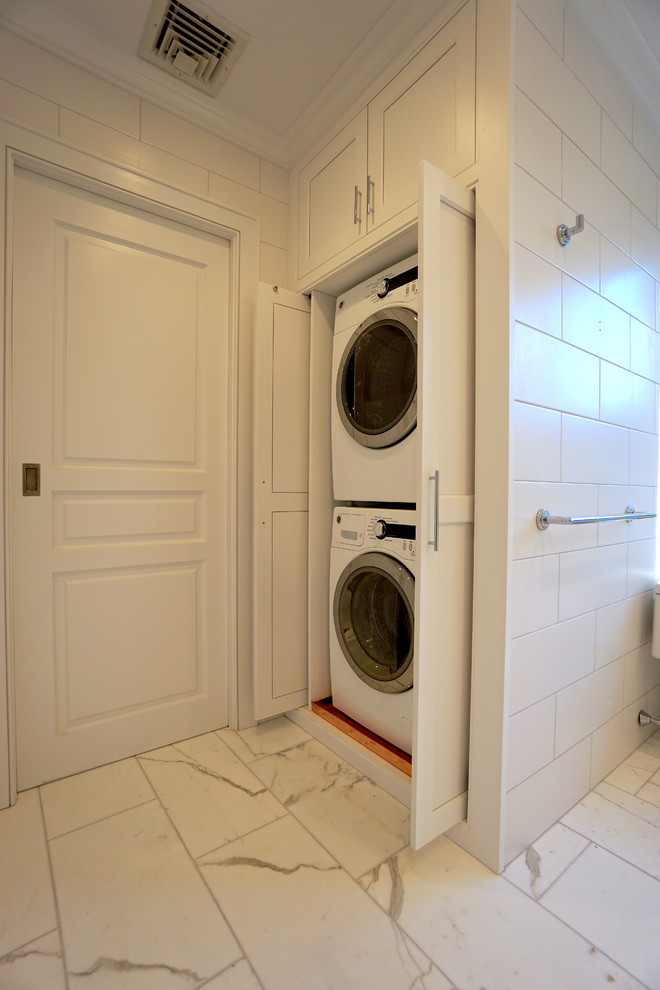 Diseño de lavadero tradicional renovado de tamaño medio con armarios con rebordes decorativos, puertas de armario blancas, paredes blancas, suelo de mármol y suelo blanco