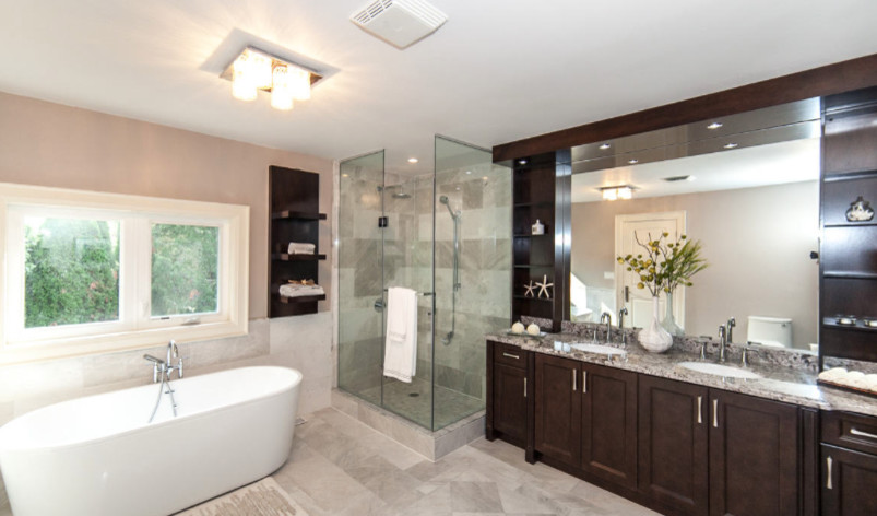 Inspiration for a large contemporary master beige tile and marble tile marble floor and beige floor bathroom remodel in Toronto with an undermount sink, a one-piece toilet, beige walls, granite countertops, shaker cabinets, dark wood cabinets and a hinged shower door