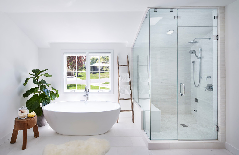 Skandinavisk inredning av ett mellanstort en-suite badrum, med ett fristående badkar, en hörndusch, vit kakel, marmorkakel, vita väggar, vitt golv, dusch med gångjärnsdörr, släta luckor, skåp i mellenmörkt trä, en toalettstol med separat cisternkåpa, marmorgolv, ett undermonterad handfat och marmorbänkskiva