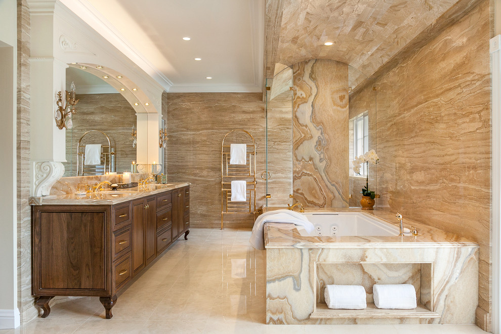 Inredning av ett klassiskt mycket stort en-suite badrum, med skåp i mörkt trä, marmorgolv, ett undermonterad handfat, marmorbänkskiva, ett undermonterat badkar, stenkakel och luckor med infälld panel