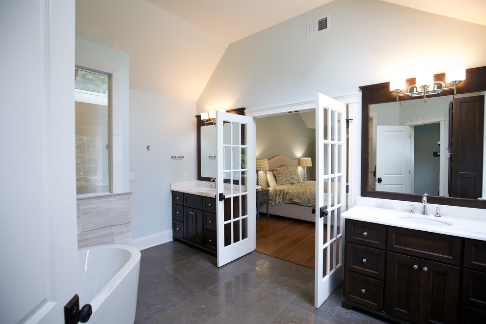 Example of a mid-sized farmhouse master gray tile and ceramic tile ceramic tile and multicolored floor bathroom design in Chicago with shaker cabinets, brown cabinets, a two-piece toilet, blue walls, a drop-in sink, granite countertops and white countertops