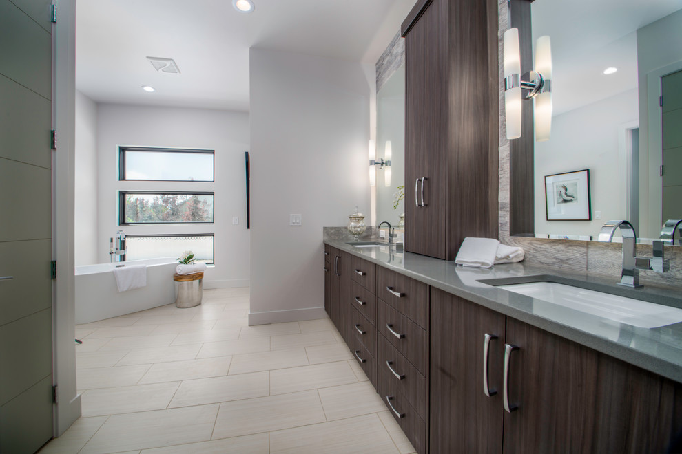Стильный дизайн: большая главная ванная комната в современном стиле с плоскими фасадами, темными деревянными фасадами, отдельно стоящей ванной, белыми стенами, полом из керамической плитки, врезной раковиной и столешницей из ламината - последний тренд