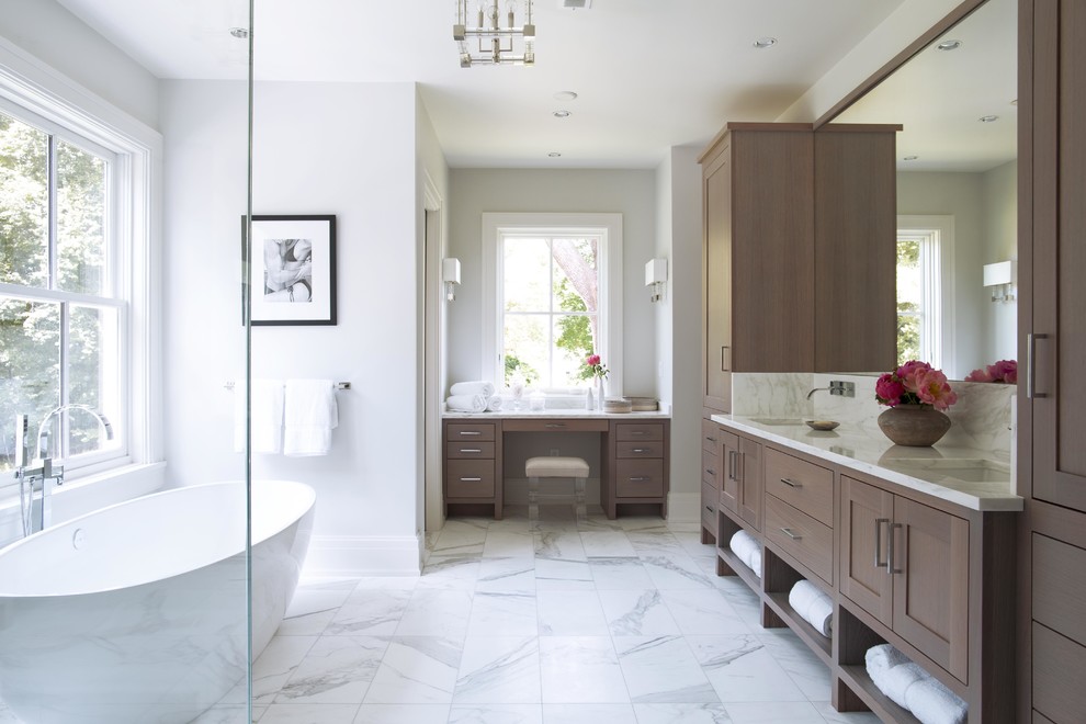 Идея дизайна: огромная главная ванная комната в стиле неоклассика (современная классика) с отдельно стоящей ванной, белыми стенами, мраморным полом, врезной раковиной, белым полом, фасадами в стиле шейкер, темными деревянными фасадами, угловым душем, серой плиткой, белой плиткой, мраморной плиткой, мраморной столешницей и душем с распашными дверями
