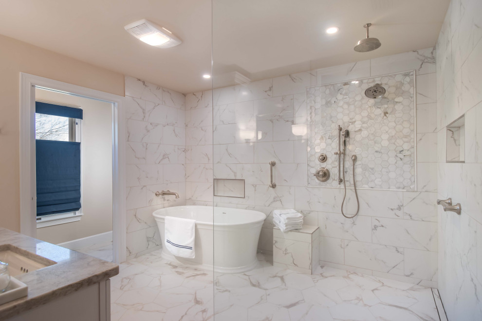 Photo of a large traditional ensuite bathroom with shaker cabinets, white cabinets, a freestanding bath, a built-in shower, a two-piece toilet, white tiles, marble tiles, grey walls, porcelain flooring, a submerged sink, engineered stone worktops, grey floors, an open shower, grey worktops, a shower bench, double sinks and a built in vanity unit.