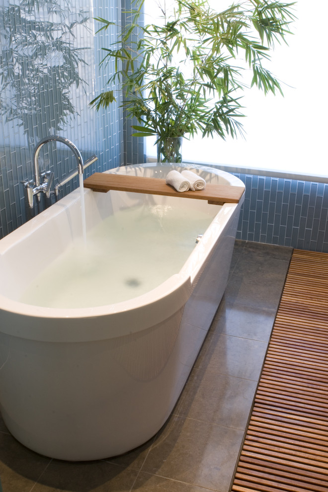 Diseño de cuarto de baño contemporáneo con bañera exenta y baldosas y/o azulejos de vidrio